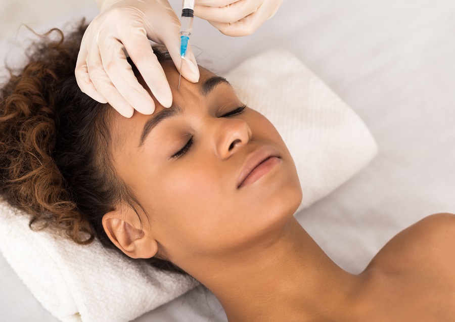 Woman getting beauty injection in forehead | Savvy Beauty and Wellness